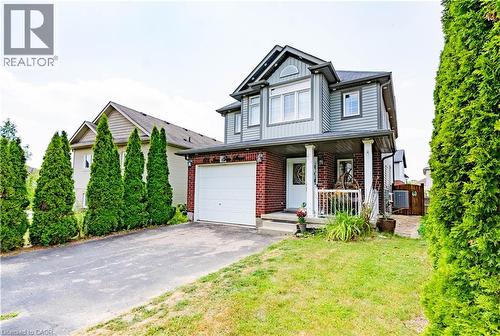 Two-story residence featuring a brick and siding exterior, an attached single-car garage, and a covered front porch with white columns - 122 Iron Gate Street, Kitchener, ON - Outdoor