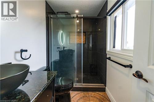 Shower with dark subway tile surround, glass enclosure, and black fixtures - 122 Iron Gate Street, Kitchener, ON - Indoor