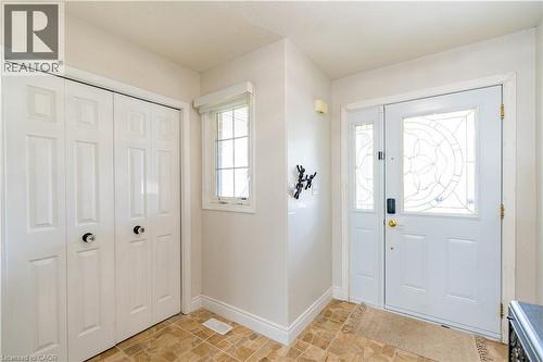 Entryway with patterned vinyl flooring, a white paneled bi-fold closet, a single window with blinds, and a white entry door with decorative glass inserts and a sidelight - 122 Iron Gate Street, Kitchener, ON - Indoor Photo Showing Other Room