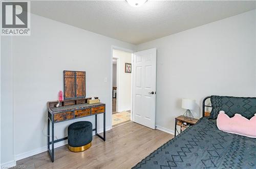 Wood-finish flooring with white walls and a six-panel interior door - 122 Iron Gate Street, Kitchener, ON - Indoor Photo Showing Bedroom