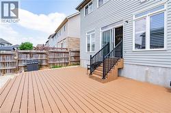 Expansive composite deck with dark railings, providing direct access to the interior through a sliding glass door - 