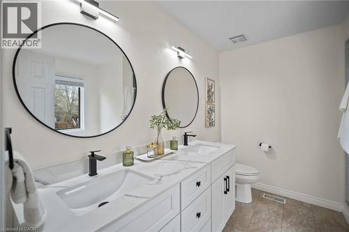 Double vanity with integrated sinks, black finish faucets, and white shaker-style cabinetry - 320 Hamilton Drive Unit# 10, Ancaster, ON - Indoor Photo Showing Bathroom