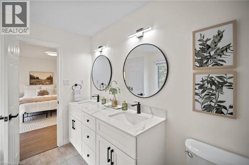 Double vanity with white cabinetry, black hardware, and integrated sinks - 320 Hamilton Drive Unit# 10, Ancaster, ON - Indoor Photo Showing Bathroom