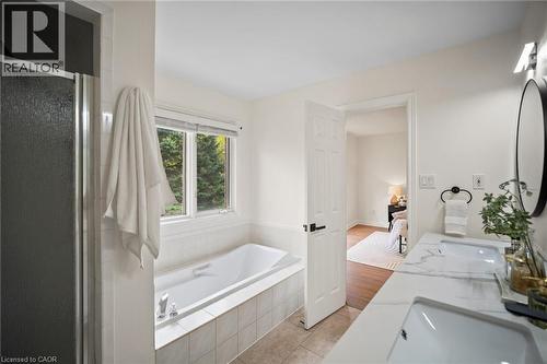 Dual vanity with integrated sinks, built-in soaking tub, separate shower enclosure, and tiled flooring - 320 Hamilton Drive Unit# 10, Ancaster, ON - Indoor Photo Showing Bathroom
