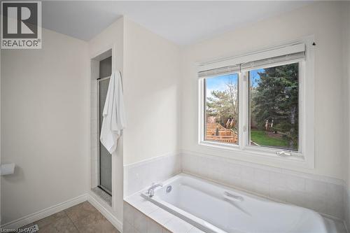 Bathtub with tiled surround, shower enclosure, and a large window - 320 Hamilton Drive Unit# 10, Ancaster, ON - Indoor Photo Showing Bathroom