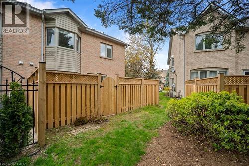 Private fenced backyard area with brick exterior and bay window feature - 320 Hamilton Drive Unit# 10, Ancaster, ON - Outdoor With Exterior
