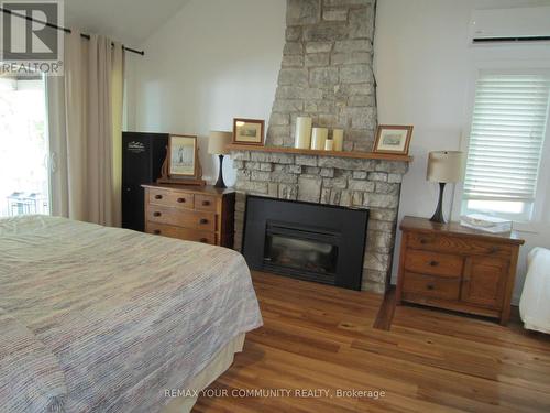 Stone Propane Fireplace - 6576 Quarry Point Road, Ramara, ON - Indoor Photo Showing Bedroom With Fireplace