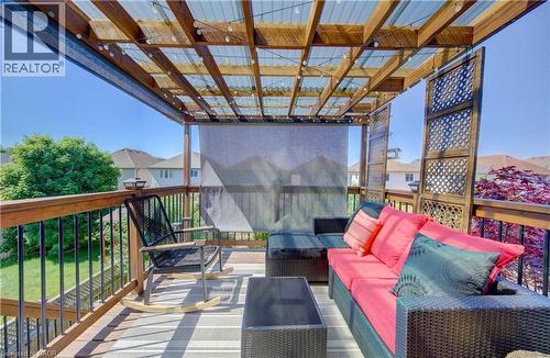 Spacious deck featuring a wooden pergola with a translucent corrugated roof, dark wood lattice panels, and black metal railings - 232 Cranbrook Street, Kitchener, ON - Outdoor With Exterior
