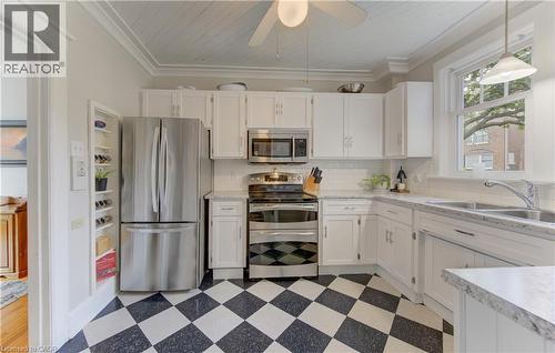 Kitchen featuring white cabinetry, stainless steel appliances, speckled countertops, and a white subway tile backsplash - 150 Union Boulevard, Kitchener, ON - Indoor Photo Showing Kitchen With Double Sink
