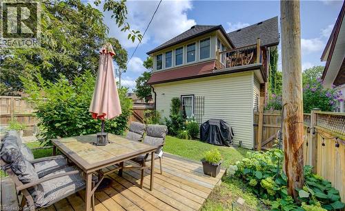 Expansive wood deck with a built-in outdoor dining area, surrounded by lush landscaping and a privacy fence - 150 Union Boulevard, Kitchener, ON - Outdoor With Deck Patio Veranda With Exterior
