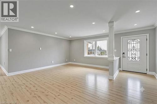 Recessed ceiling lighting, crown molding, light wood-finish flooring, and a decorative glass entry door with a sidelight - 44 Mcclellan Road, Alton, ON - Indoor Photo Showing Other Room
