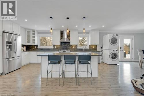 Contemporary kitchen featuring stainless steel appliances, white cabinetry, a central island with pendant lighting, and light wood-finish flooring - 44 Mcclellan Road, Alton, ON - Indoor Photo Showing Kitchen With Upgraded Kitchen