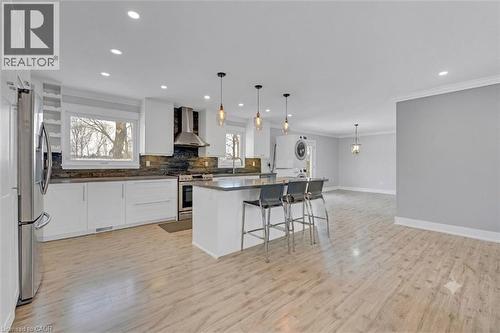 Open-concept living space with wood-finish flooring, white cabinetry, stainless steel appliances, a kitchen island, and recessed lighting - 44 Mcclellan Road, Alton, ON - Indoor Photo Showing Kitchen With Upgraded Kitchen
