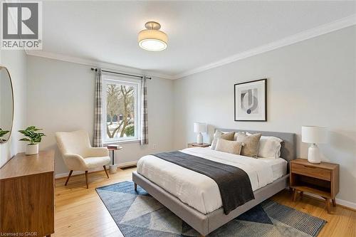 *VIRTUALLY STAGED* Light wood-finish flooring, crown molding, and a modern ceiling light fixture - 44 Mcclellan Road, Alton, ON - Indoor Photo Showing Bedroom