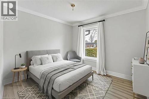 *VIRTUALLY STAGED* Light-toned wood-finish flooring, crown molding, and a single window with black-finish hardware - 44 Mcclellan Road, Alton, ON - Indoor Photo Showing Bedroom