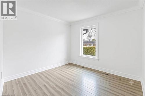 Smooth-finish walls, wood-finish flooring, white window trim, and crown molding - 44 Mcclellan Road, Alton, ON - Indoor Photo Showing Other Room