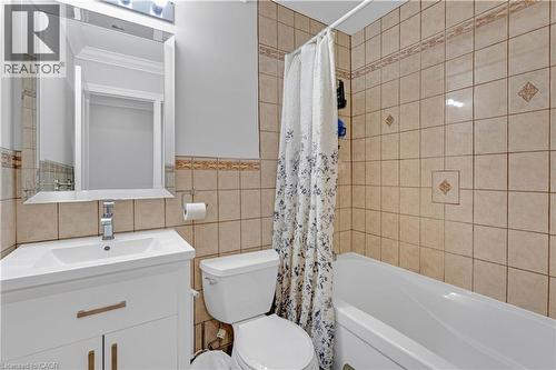 White vanity with an integrated sink and chrome faucet, framed mirror, and vanity lighting - 44 Mcclellan Road, Alton, ON - Indoor Photo Showing Bathroom