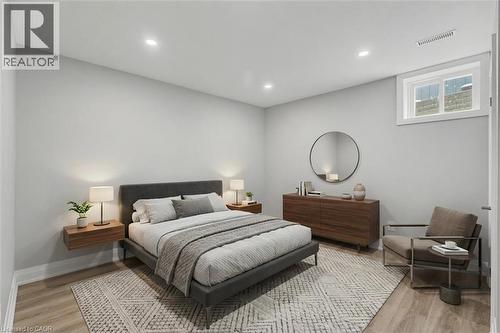 *VIRTUALLY STAGED* Recessed ceiling lighting, wood-finish flooring, white trim, and a window with white casing - 44 Mcclellan Road, Alton, ON - Indoor Photo Showing Bedroom