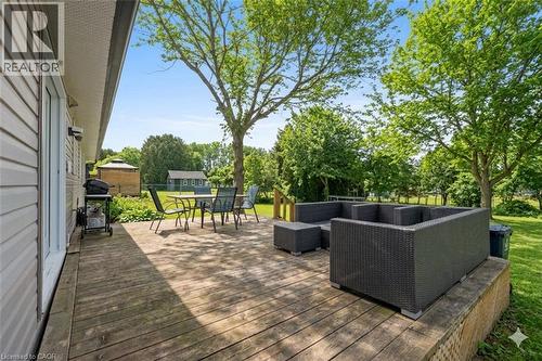 Spacious wood deck with an additional raised platform, bordered by mature trees, and featuring a manicured lawn - 44 Mcclellan Road, Alton, ON - Outdoor With Deck Patio Veranda