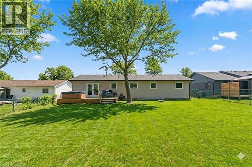 Expansive backyard featuring a manicured lawn, wood deck, and French patio doors - 44 Mcclellan Road, Alton, ON - Outdoor With Deck Patio Veranda With Backyard With Exterior
