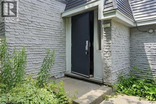 Exterior entry featuring a dark-colored door, concrete landing, and textured siding - 509 Quiet Place Unit# 1, Waterloo, ON - Outdoor