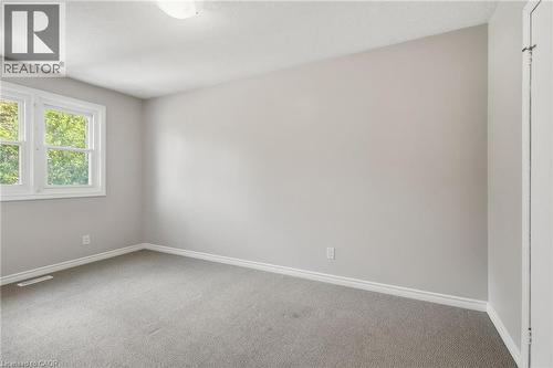 Spacious room featuring light gray wall paint, white trim, gray carpet flooring, and a two-pane window - 509 Quiet Place Unit# 1, Waterloo, ON - Indoor Photo Showing Other Room