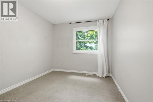 Carpeted room with a double-paned window, neutral wall paint, white trim, and a white ceiling - 509 Quiet Place Unit# 1, Waterloo, ON - Indoor Photo Showing Other Room