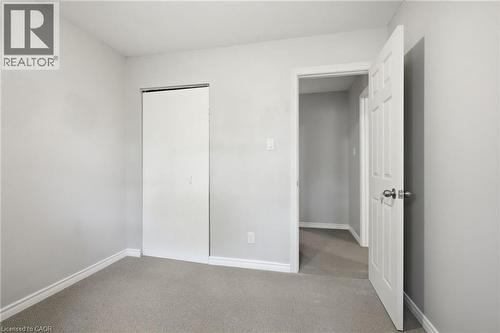 Neutral gray wall paint with white trim, gray carpet flooring, and a sliding closet door - 509 Quiet Place Unit# 1, Waterloo, ON - Indoor Photo Showing Other Room
