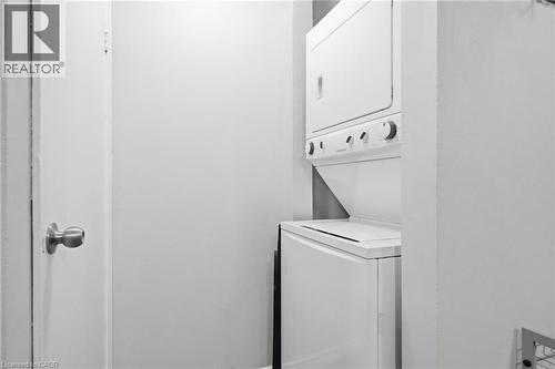 Compact laundry area featuring a stacked washer and dryer unit - 509 Quiet Place Unit# 1, Waterloo, ON - Indoor Photo Showing Laundry Room