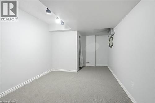 Spacious room featuring light grey carpeting, white baseboards, and track lighting with three adjustable fixtures - 509 Quiet Place Unit# 1, Waterloo, ON - Indoor Photo Showing Other Room