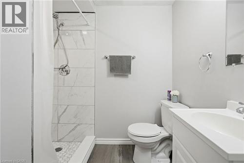 Bathroom featuring a shower with white marble-patterned wall tiles and a white hexagonal floor tile - 509 Quiet Place Unit# 1, Waterloo, ON - Indoor Photo Showing Bathroom