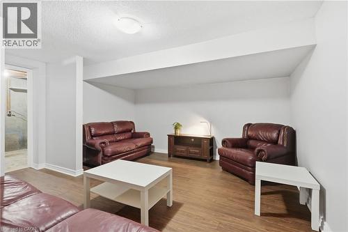 Finished basement space featuring wood-finish flooring, white painted walls, white trim, and a flush-mount ceiling light fixture - 509 Quiet Place Unit# 1, Waterloo, ON - Indoor