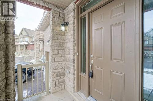 Stone veneer exterior with a paneled entry door, transom window, and side window - 70 Bradbury Road, Hamilton, ON -  With Exterior