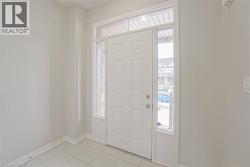 Entryway featuring a white paneled door, transom window, and sidelights - 
