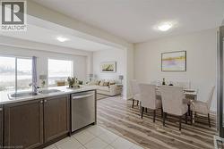 Open-concept living space with wood-finish flooring, white walls, and recessed lighting - 