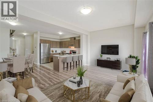 Open concept living space featuring wood-finish flooring, a kitchen island with seating, stainless steel appliances, and recessed lighting - 70 Bradbury Road, Hamilton, ON - Indoor Photo Showing Living Room