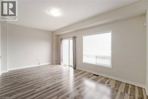 Wood-finish flooring, white trim, sliding glass door, recessed ceiling, and a large window - 70 Bradbury Road, Hamilton, ON - Indoor Photo Showing Other Room