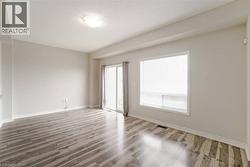 Wood-finish flooring, white trim, sliding glass door, recessed ceiling, and a large window - 