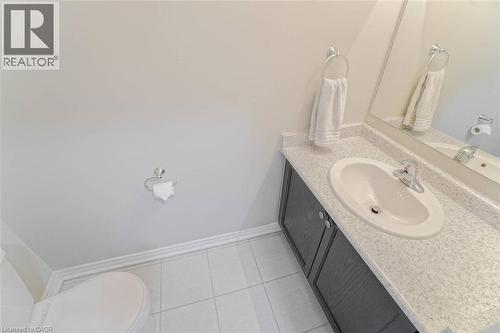 Vanity with gray cabinetry, an integrated sink, and speckled countertop - 70 Bradbury Road, Hamilton, ON - Indoor Photo Showing Bathroom