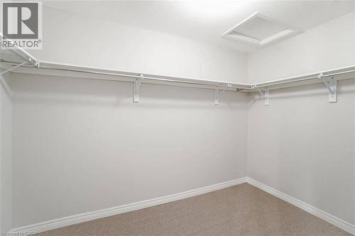 Walk-in closet featuring carpet flooring, built-in shelving, and hanging rods - 70 Bradbury Road, Hamilton, ON - Indoor With Storage