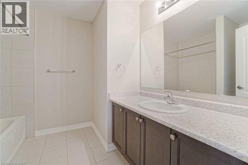 Integrated vanity with a solid surface countertop, undermount sink, and dark wood-finish cabinetry - 70 Bradbury Road, Hamilton, ON - Indoor Photo Showing Bathroom