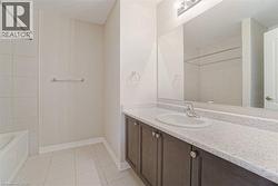 Integrated vanity with a solid surface countertop, undermount sink, and dark wood-finish cabinetry - 