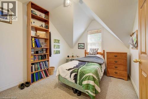 Built-in shelving, sloped ceilings, wall-to-wall carpeting, window with natural light, and a natural wood-finish door - 875 Safari Road, Hamilton, ON 