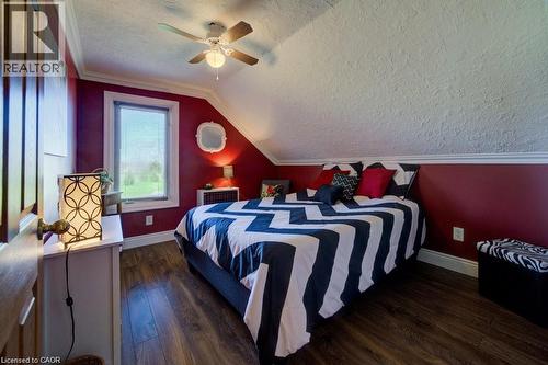 Wood-finish flooring, ceiling fan with integrated lighting, window with blinds, baseboard trim, and a sloped ceiling - 875 Safari Road, Hamilton, ON 