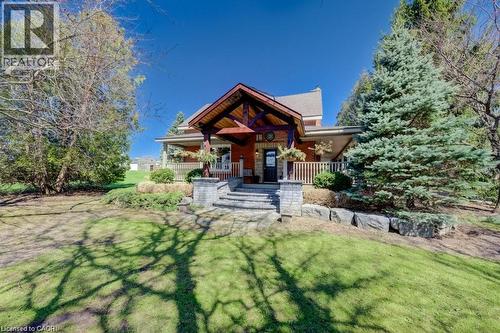 Red brick exterior with a prominent covered entry featuring exposed wood beams - 875 Safari Road, Hamilton, ON 