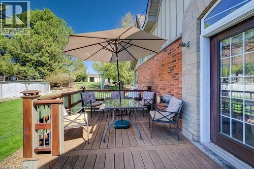 Wood-finish deck with a built-in railing, brick exterior, and a glass-paneled door with an arched transom - 875 Safari Road, Hamilton, ON 