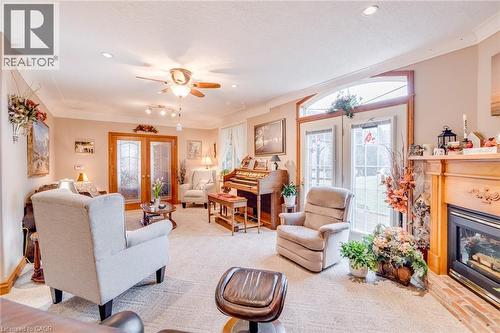 Recessed ceiling lighting, crown molding, double glass-paneled doors, arched transom window, and a fireplace with a wood mantel - 875 Safari Road, Hamilton, ON 