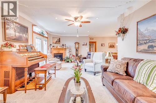 Recessed lighting, ceiling fan, fireplace with wood mantel, light-toned carpeting, and crown molding - 875 Safari Road, Hamilton, ON 