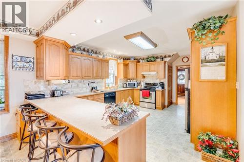 Kitchen featuring wood cabinetry, light-toned countertops, a full suite of appliances, and recessed lighting - 875 Safari Road, Hamilton, ON 