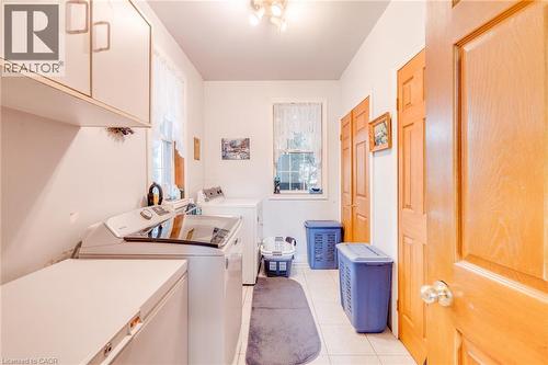 White wall cabinetry, ceiling-mounted light fixture, tile flooring, and wood-paneled doors - 875 Safari Road, Hamilton, ON 